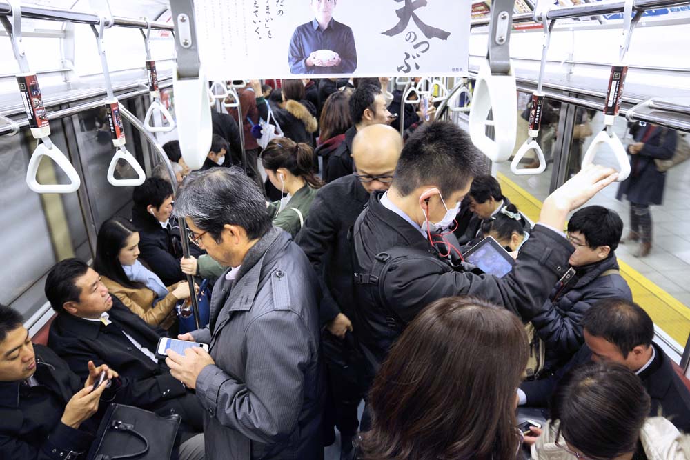 Packed train and people are using their smartphone in the train